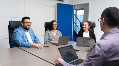 Charles-Alexandre Monette, Rébecca Gascon-Bruneau, Julie Thériault et Julien Lord, échangeant autour d'une table dans la salle de conférence.